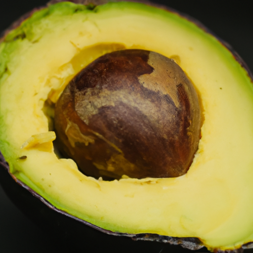 A ripe avocado cut in half with the inside exposed to reveal its creamy green texture.